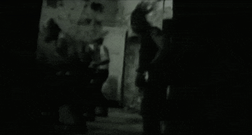 a black and white photo of a person holding a gun .