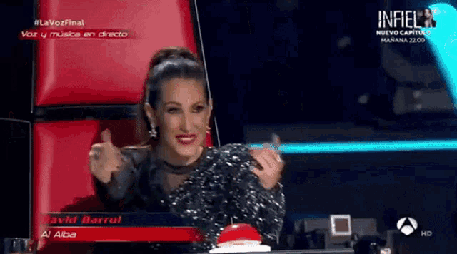 a woman giving a thumbs up in front of a sign that says lavozfinal