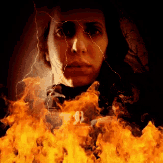 a woman is surrounded by flames and lightning strikes