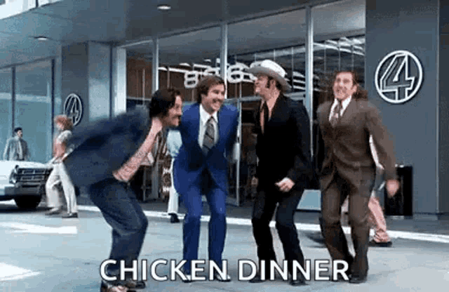 a group of men in suits and ties are dancing on the sidewalk in front of a building .