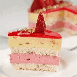 a slice of cake with strawberries on top of it is on a white plate .