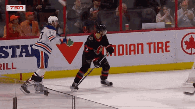 a hockey game is being played in front of a canadian tire sign