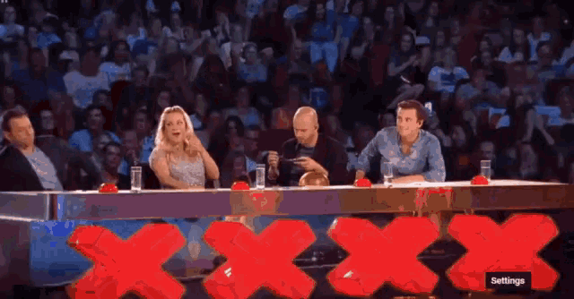 a group of people sitting at a table with a red x on it