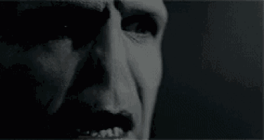 a close up of a person 's face with white paint on it and a black background .