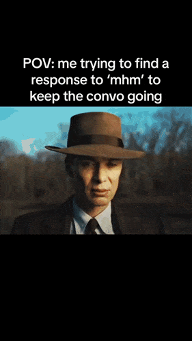 a man in a hat is covering his mouth with his hand