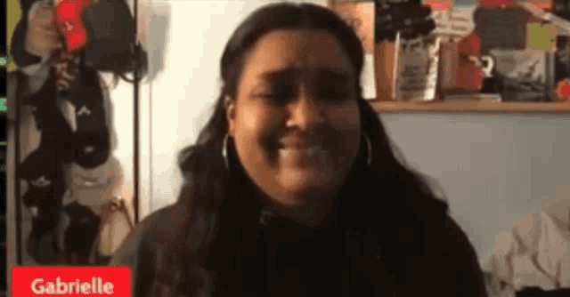 a woman named gabrielle is smiling in a video call