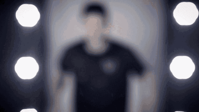 a blurry picture of a man standing in front of a wall of lights