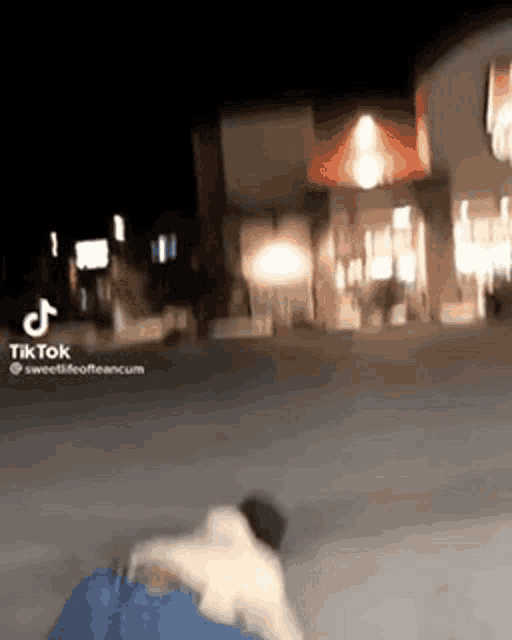 a person is walking down a street at night with a dog .