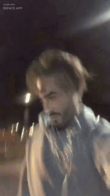 a man with a beard is wearing a blue jacket and a scarf .