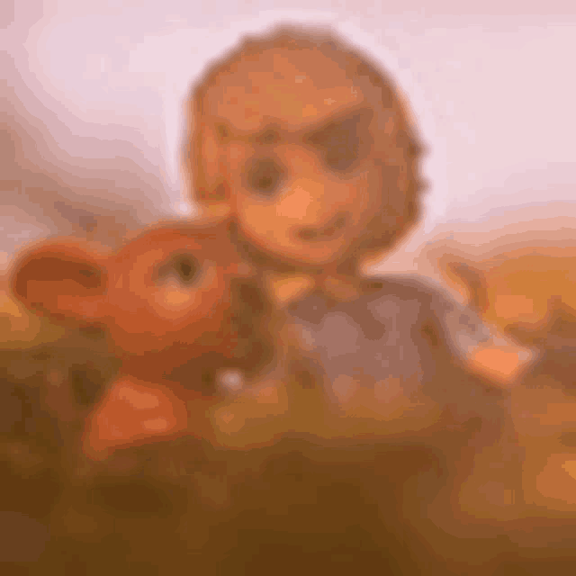 a blurry picture of a doll and a stuffed animal .