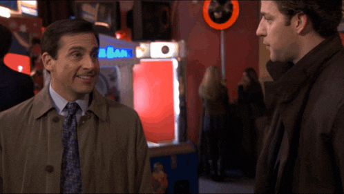 two men are standing next to each other in front of a sega machine
