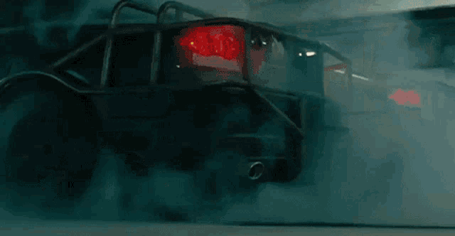 two cars are doing a burnout in a dark room