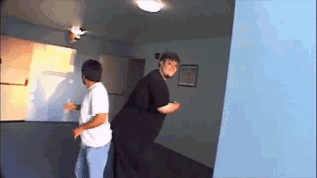 a man and a woman are dancing in a room .