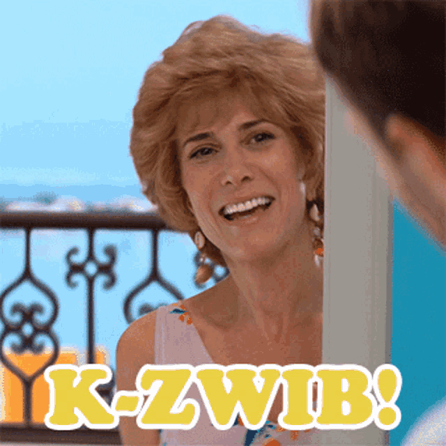 a woman is smiling in front of a sign that says k-zwib on it