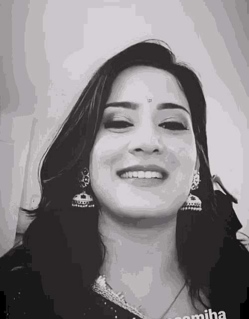 a black and white photo of a smiling woman with the name pomisha on the bottom right