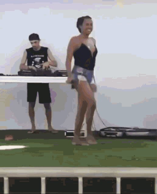 a woman is dancing in front of a dj who is wearing a black shirt that says ' abercrombie & fitch '