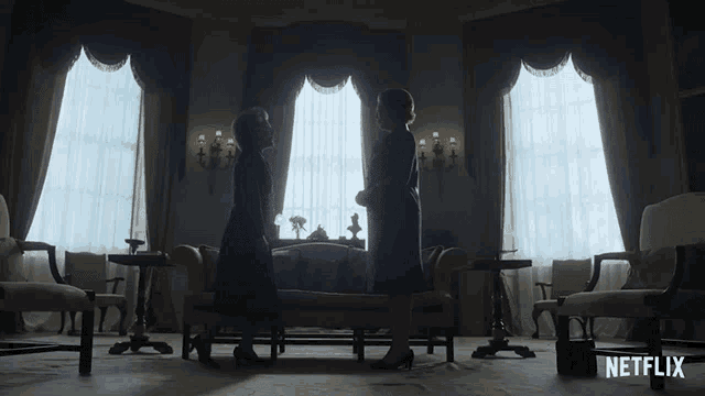 two women kneeling in front of a couch with a netflix logo in the corner