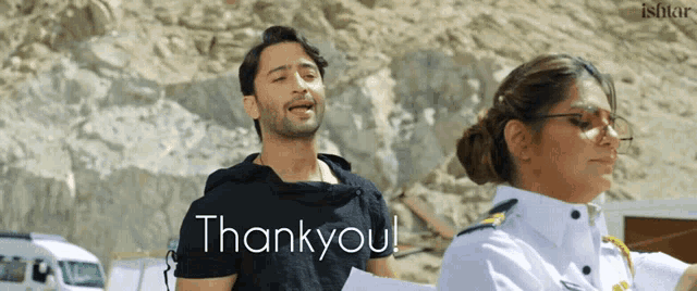 a man in a black shirt stands next to a woman in a white uniform with the words thank you written on it