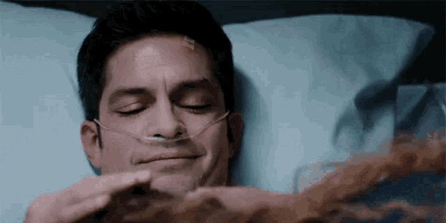 a man in a hospital bed with an oxygen mask on his face .