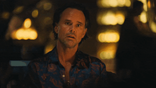 a man in a floral shirt is looking at something