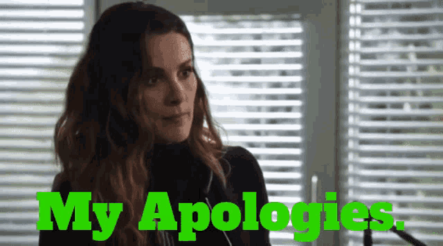 a woman is standing in front of a window with blinds and the words my apologies in green letters