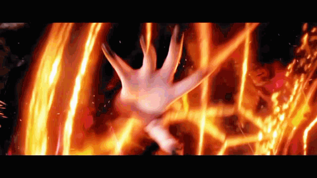 a person 's hand is reaching out towards a fire
