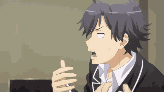 a man with a surprised look on his face is wearing a black suit