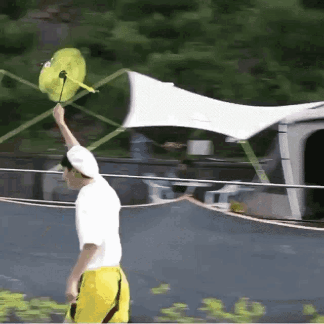 a man in yellow shorts is holding a yellow kite