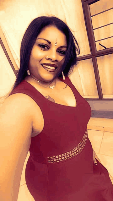 a woman in a red dress with a tattoo on her forehead