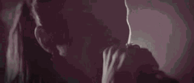 a black and white photo of a woman screaming into a microphone .