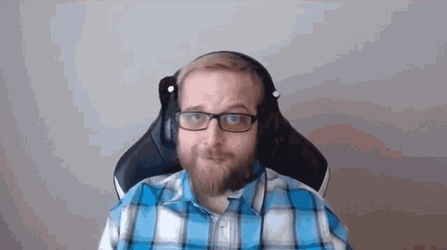 a man with a beard wearing headphones and a plaid shirt