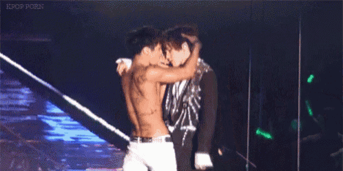 two men are kissing on a stage and the words kpop porn are on the bottom