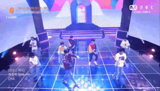 a group of young men are dancing on a stage in front of a mnet logo