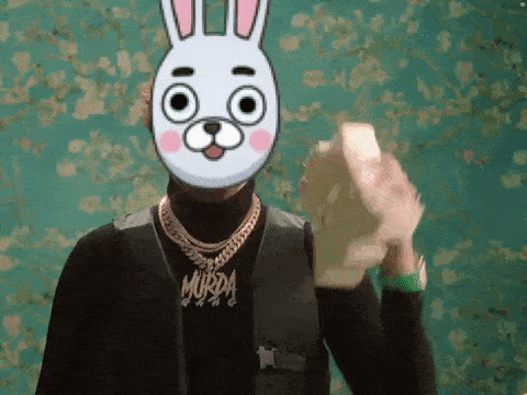 a man wearing a bunny mask is holding a bunch of money in his hand .