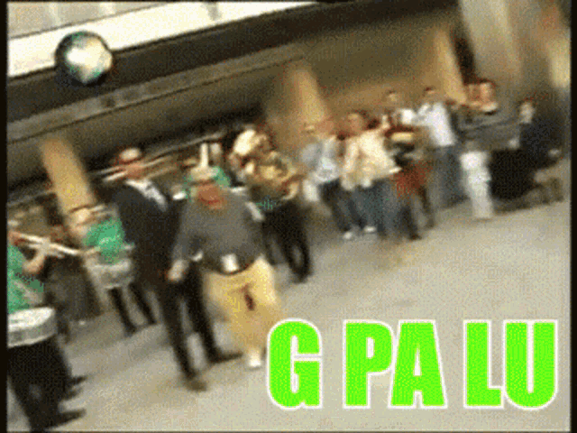a group of people are dancing in front of a sign that says g pa lu on it