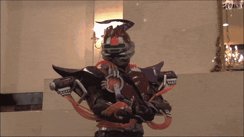 a man in a costume with the letter r on his chest is holding a gun