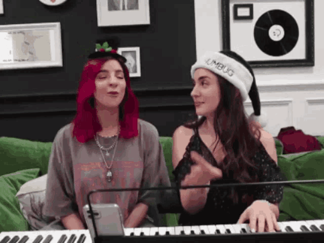 a woman with red hair is singing while another woman plays a keyboard