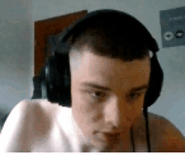 a shirtless young man wearing headphones is looking at the camera .
