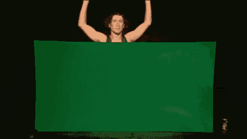 a man is holding up a large green sheet