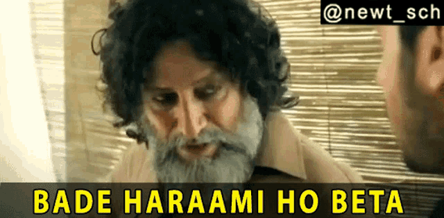 a man with a beard and curly hair talks to another man
