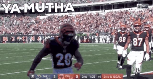 a football player with the number 28 on his jersey runs on the field