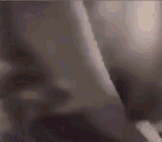 a blurry image of a person 's face with a purple and orange background