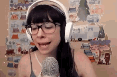 a woman wearing glasses and headphones singing into a microphone
