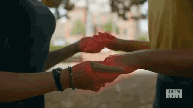 a person is holding another person 's hand with red light coming out of it .