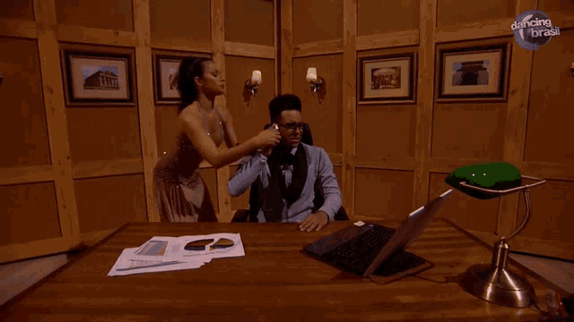 two men are sitting at a desk with dancing with the stars written on the corner