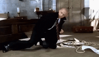a man in a suit and tie is kneeling on the floor in a room