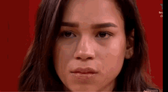 a close up of a woman 's face with a red background