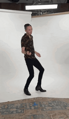a man in a brown shirt and black pants is dancing