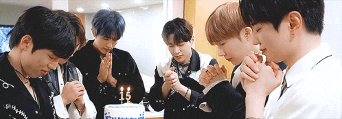 a group of young men are praying in front of a birthday cake with the number 15 on it