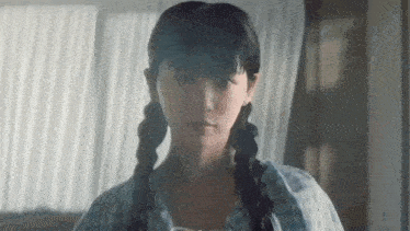 a close up of a woman with pigtails looking at the camera .